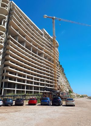 House construction with crane and parked cars in Petrovac, Montenegro